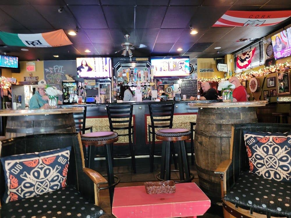 The main bar with taps, TVs, and a Cork flag overhead