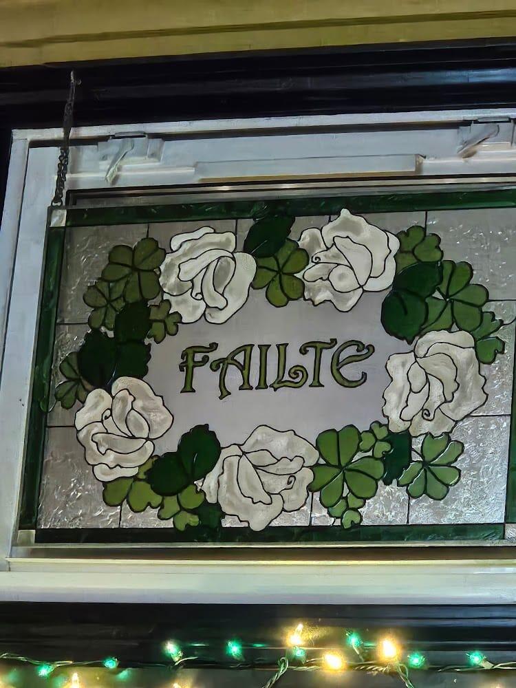 Stained-glass Fáilte window with white roses and shamrocks